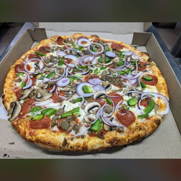 Shakey Jake's pizza with pepperoni, sausage, mushrooms, green peppers, and red onions in a box.