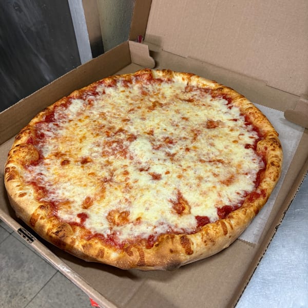 A freshly baked Shakey Jake's cheese pizza with a golden crust sits in an open cardboard box.